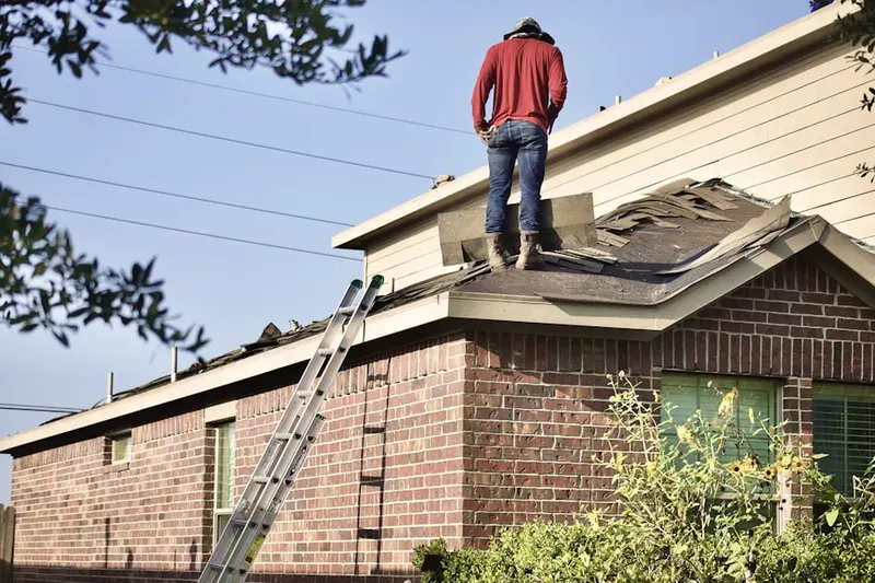 Professional roofer working on a residential roof in Country Club Highlands